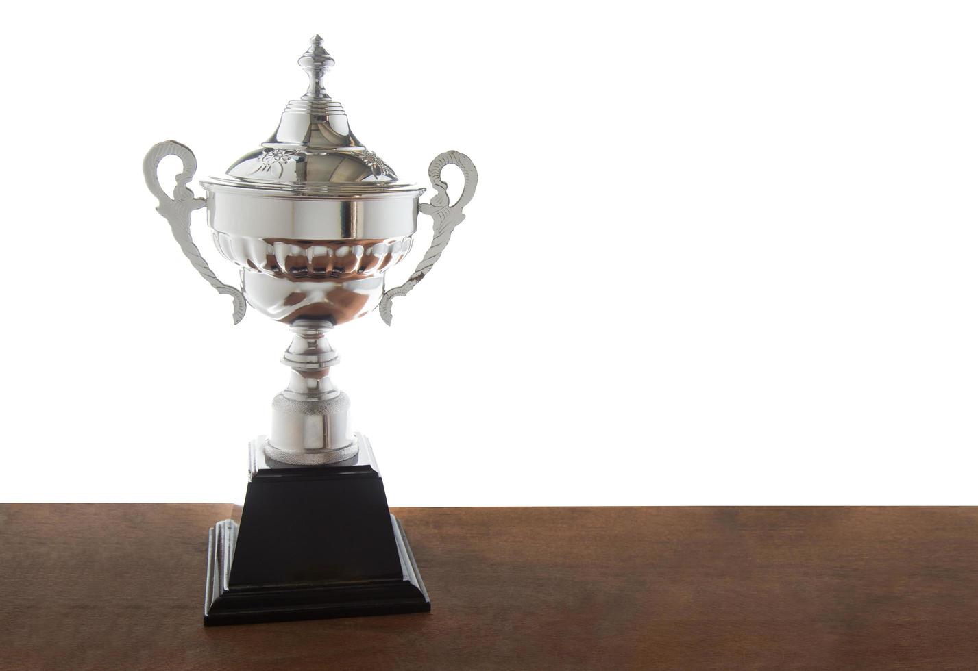 Trophée d'argent sur un bureau sur fond blanc photo