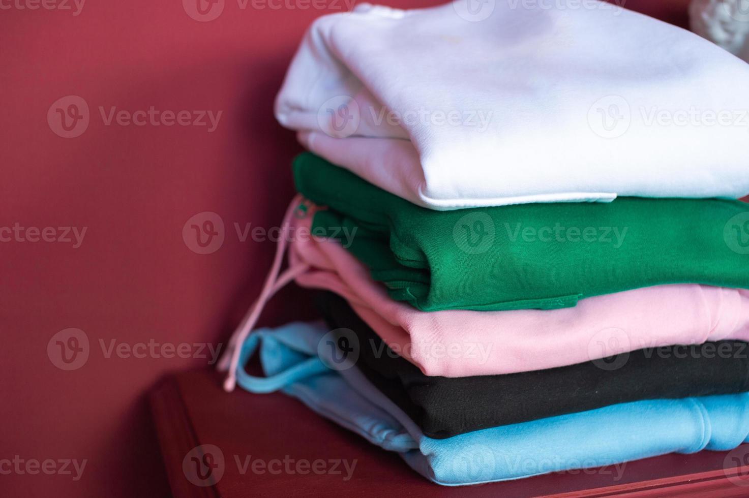 sur le table sont soigneusement plié sweats à capuche dans le intérieur, une modèle de sweats à capuche dans différent couleurs photo