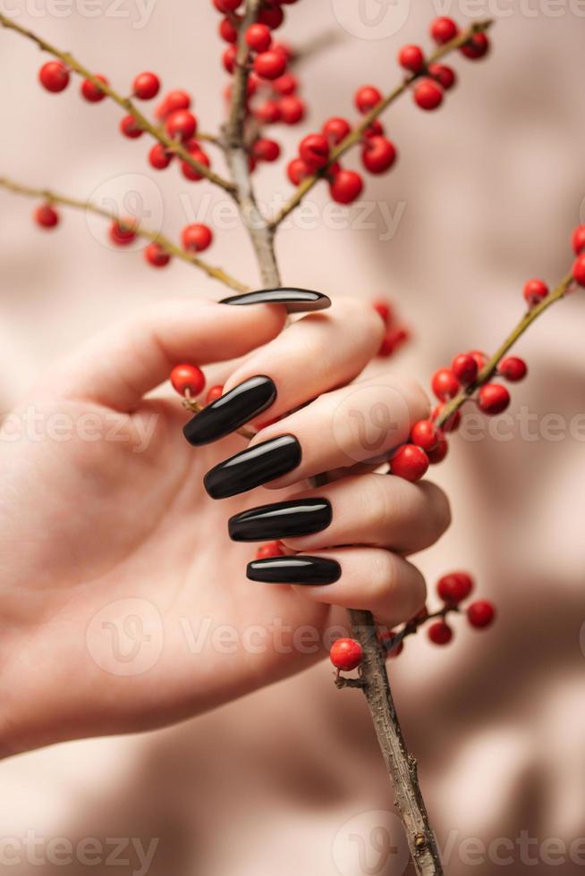 mains d'une jeune fille avec une manucure noire sur les ongles photo