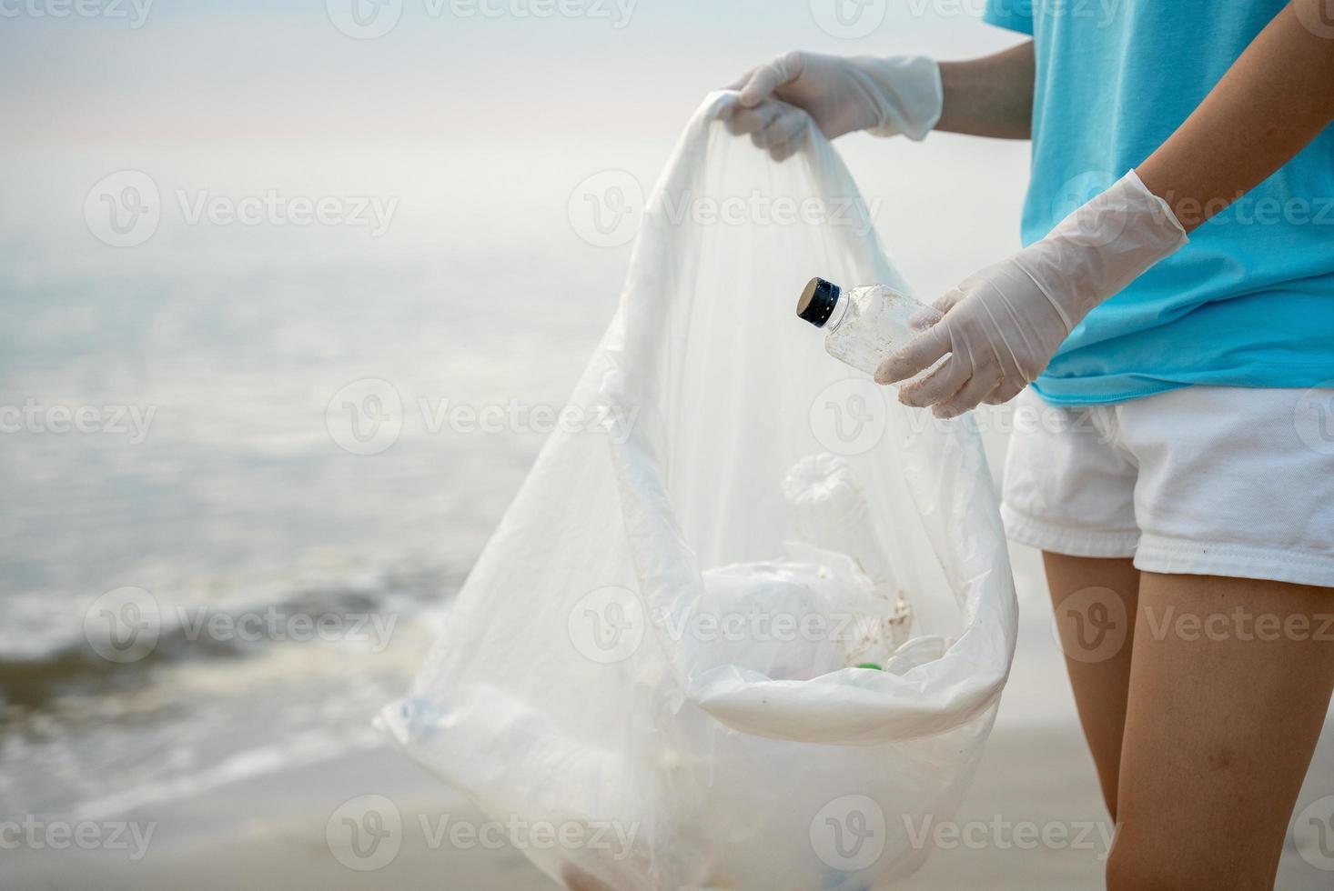 bénévole choisir en haut poubelle des ordures à le plage et Plastique bouteilles sont difficile décomposer prévenir nuire aquatique vie. Terre, environnement, écologisation planète, réduire global échauffement, enregistrer monde photo