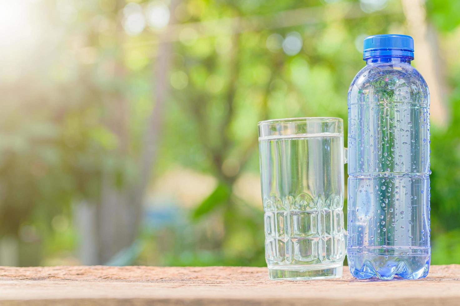 bouteille d'eau potable et verre avec fond naturel photo