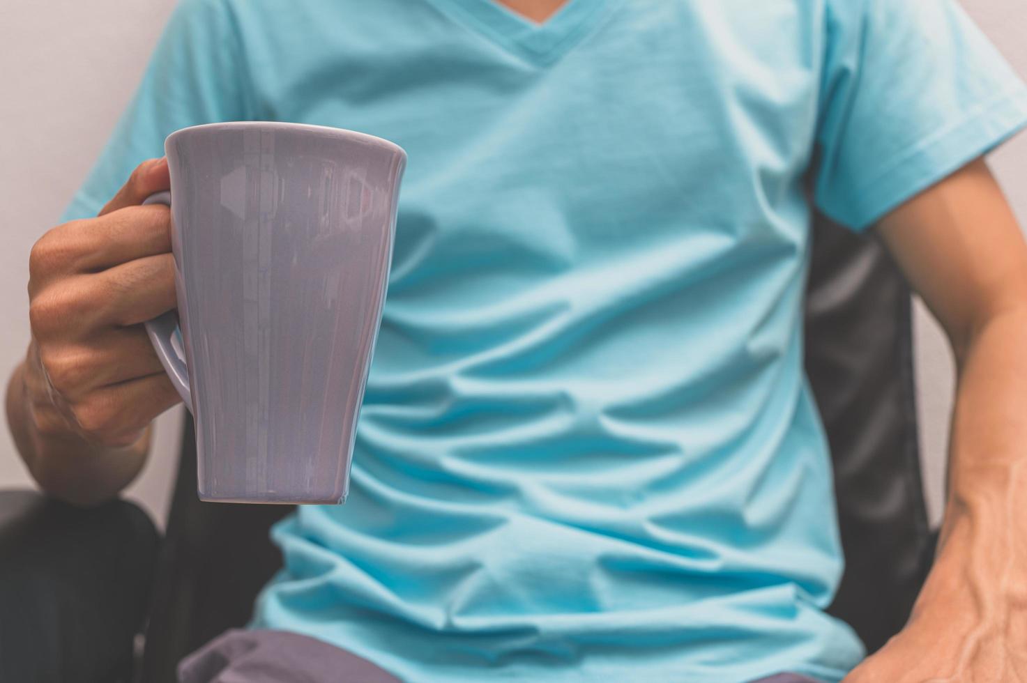 un homme tenant une tasse de café photo