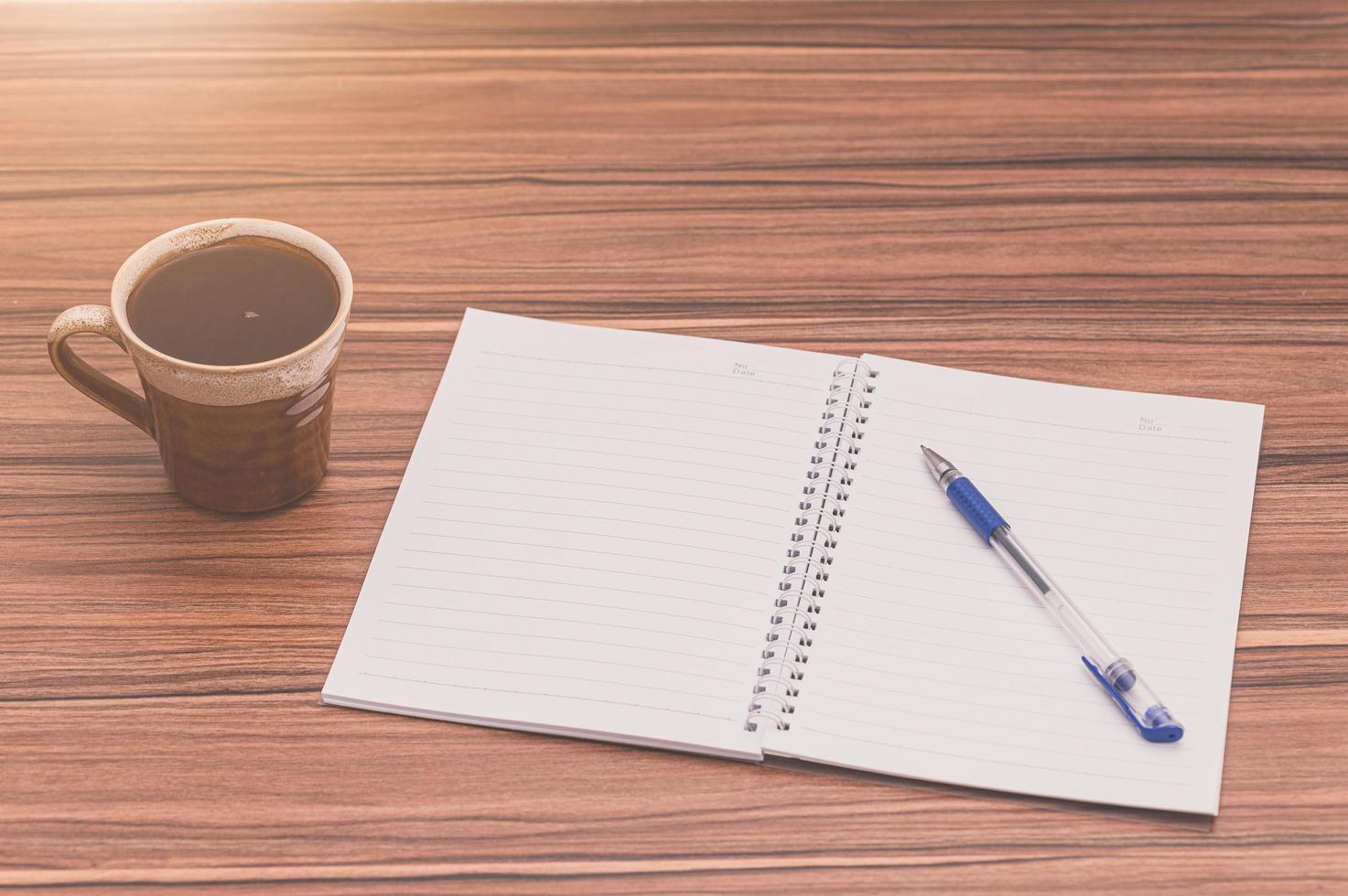 café et un bloc-notes sur table en bois photo