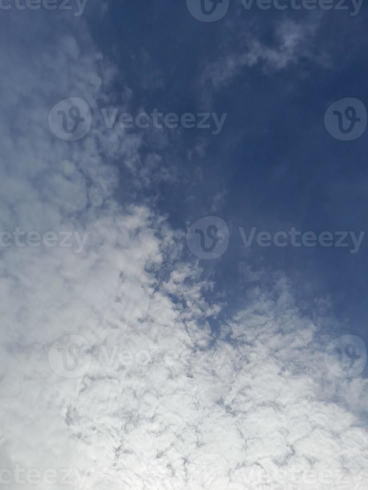 nuages blancs dans le ciel bleu. beau fond bleu clair. peu nuageux, beau temps. nuages bouclés par une journée ensoleillée. photo