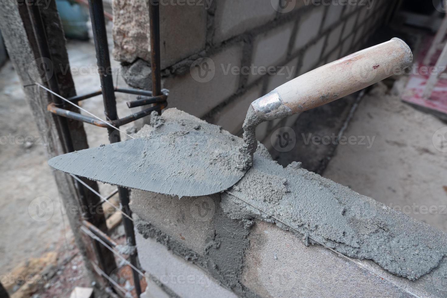 sélectivement concentrer sur le sale ciment cuillère car il est utilisé à installer briques, dans indonésien le ciment cuillère est appelé cetok, doux concentrer photo