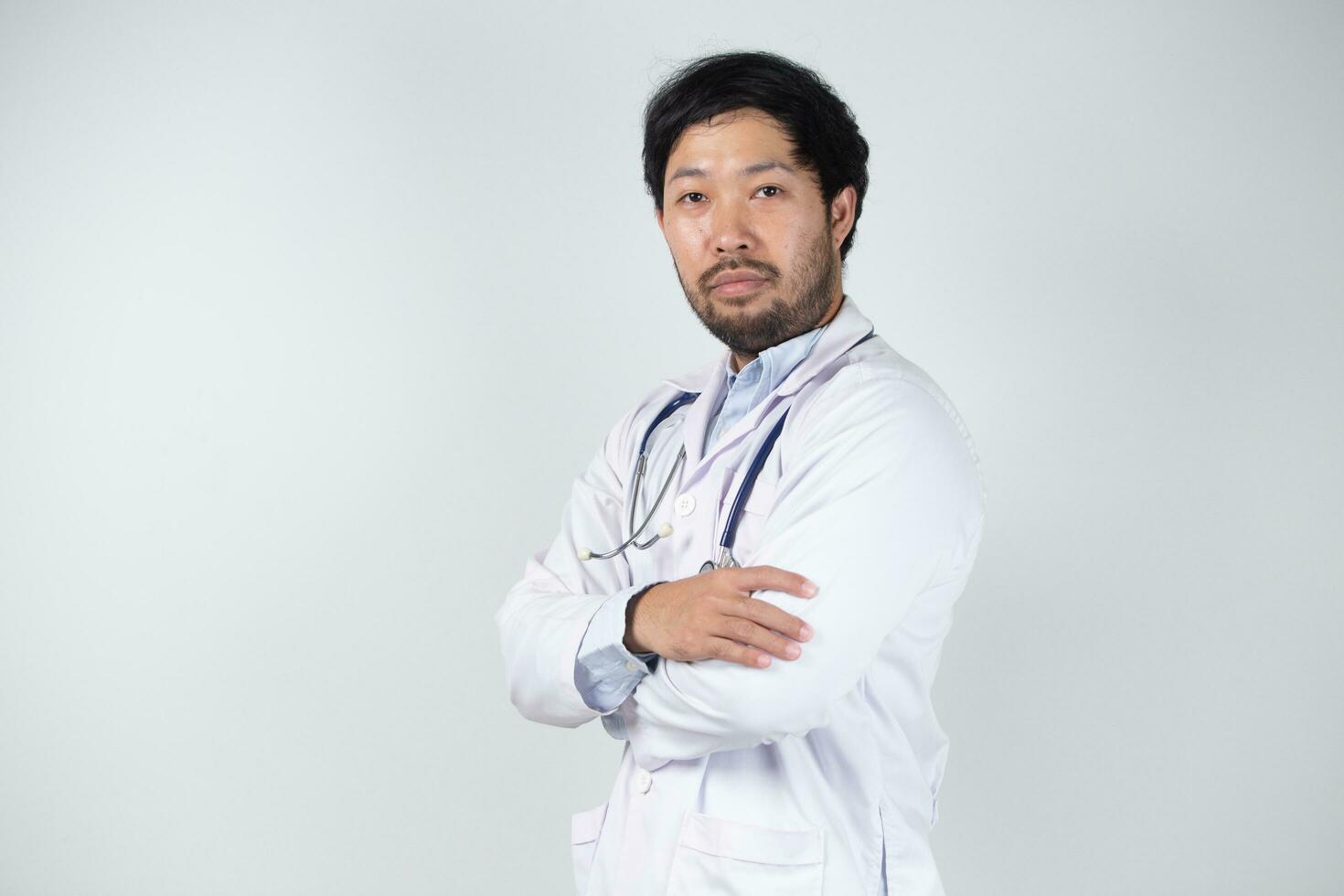 asiatique homme dans médecin uniforme sur blanc Contexte dans hôpital photo