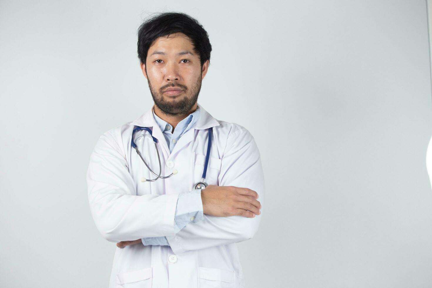 asiatique homme dans médecin uniforme sur blanc Contexte dans hôpital photo