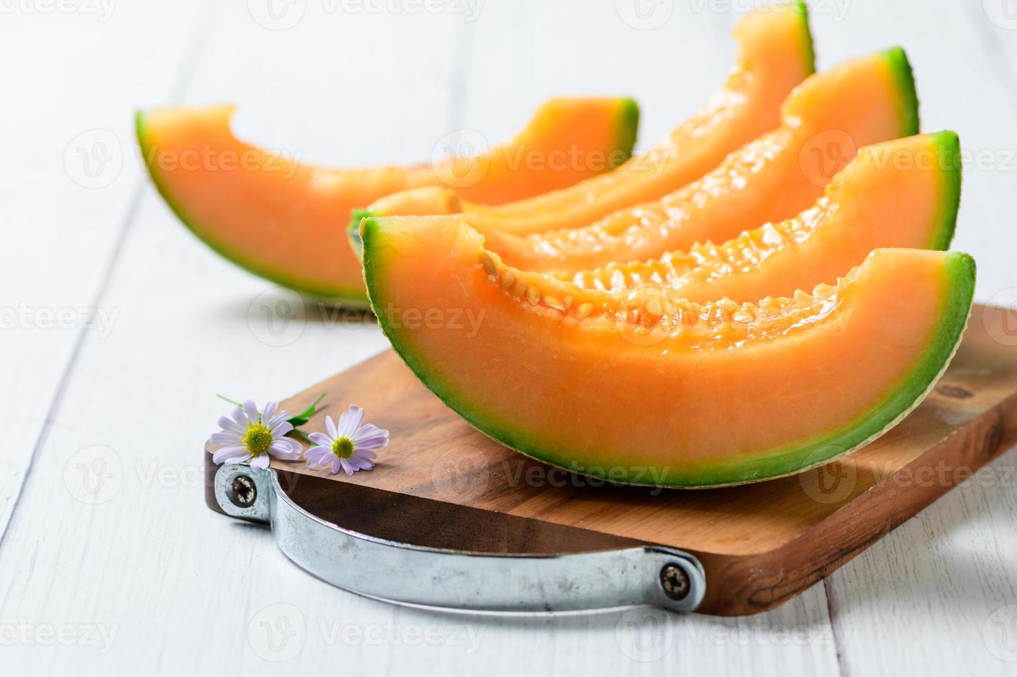 tranché de Japonais melons mon chéri melon ou cantaloup cucumis melo sur blanc en bois photo