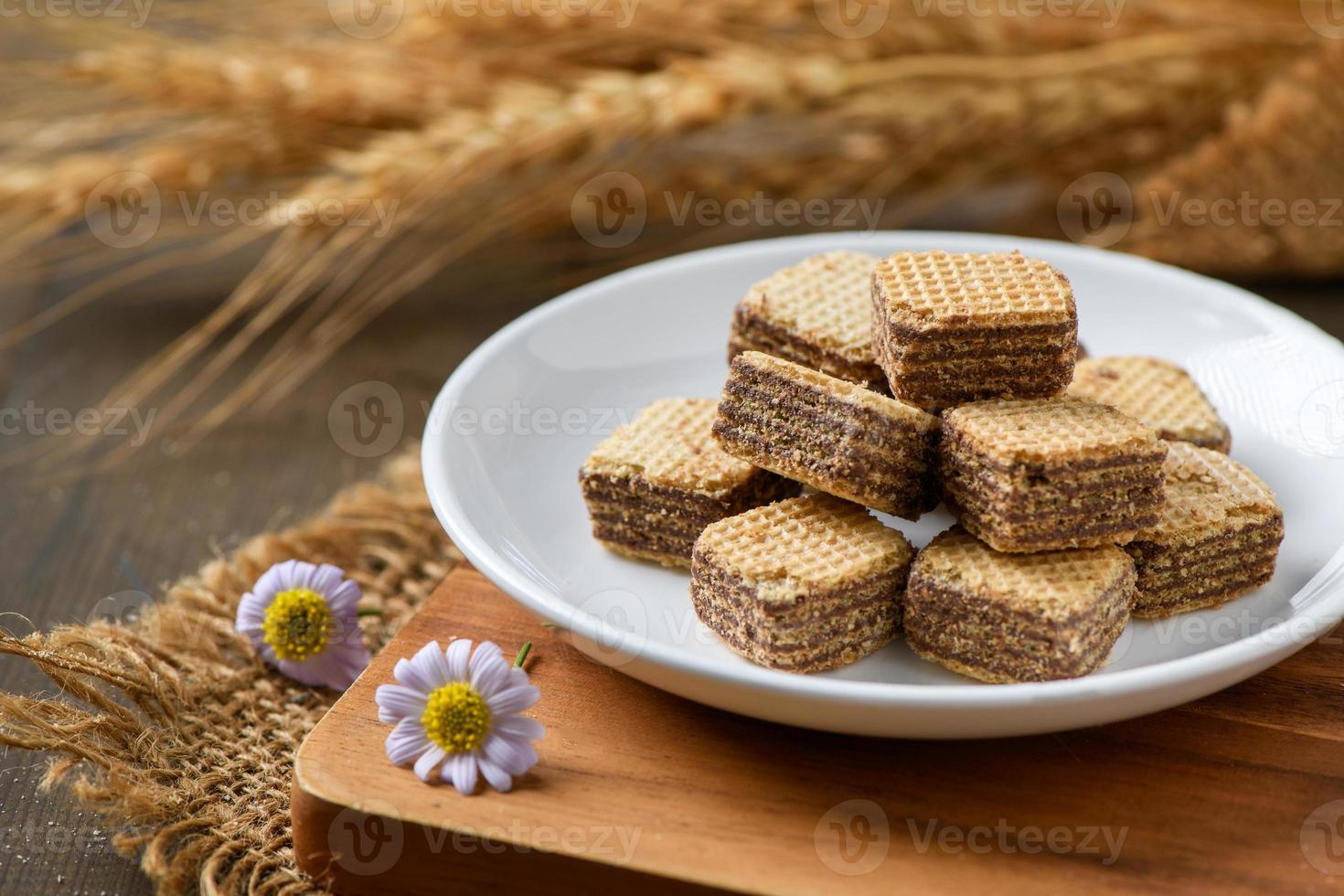 carré Chocolat tranche des biscuits dans blanc plat avec fleur orge Contexte photo
