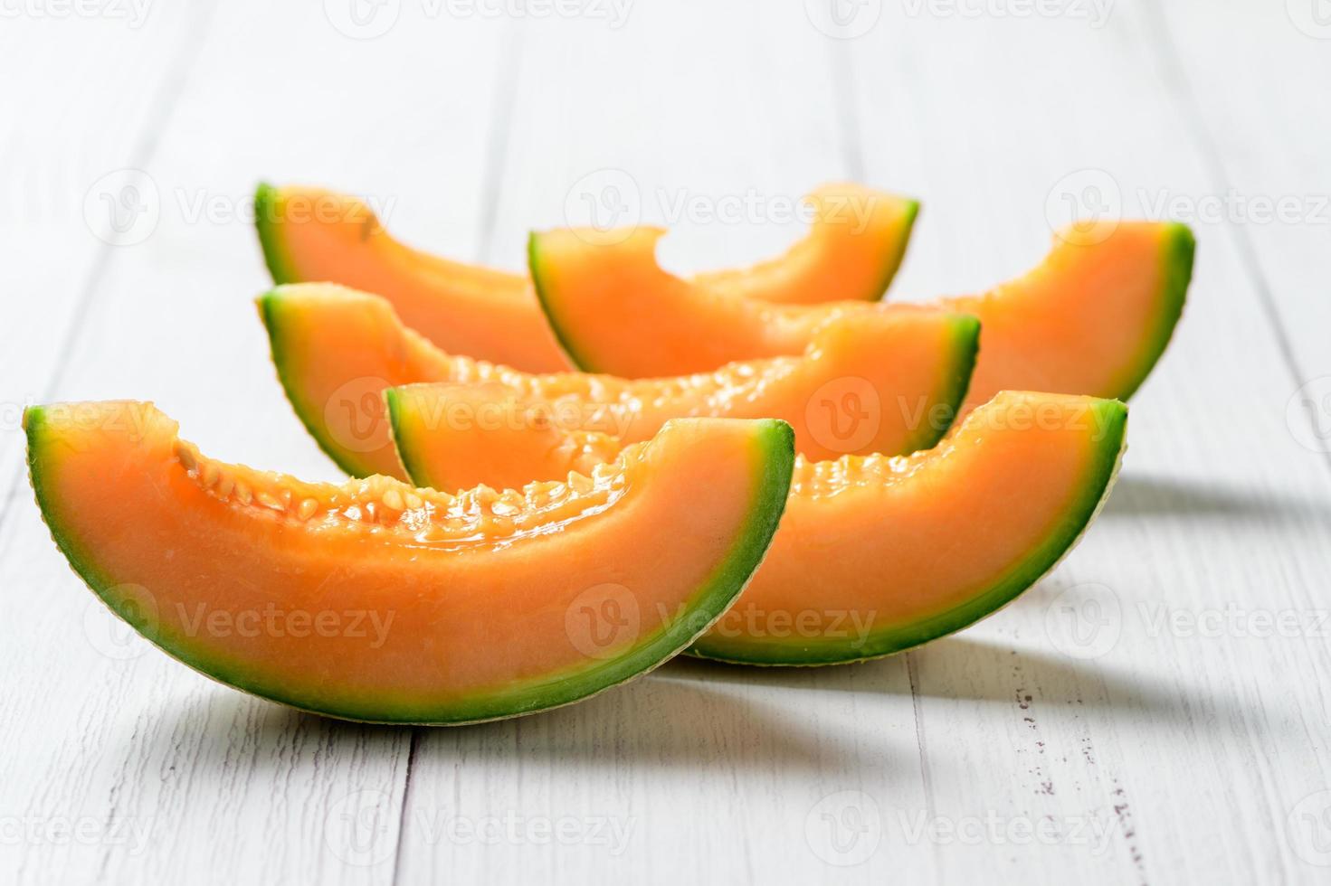 tranché de Japonais melons, miel melon ou cantaloup sur blanc en bois table photo