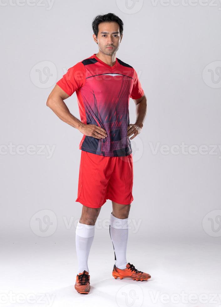 Masculin footballeur portant athlétique uniforme et chaussures, permanent toujours, sur de soi posture selon à athlète personnalité. photo