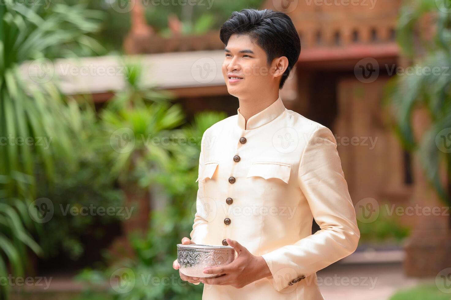 portrait bel homme au festival de songkran avec bol d'eau photo