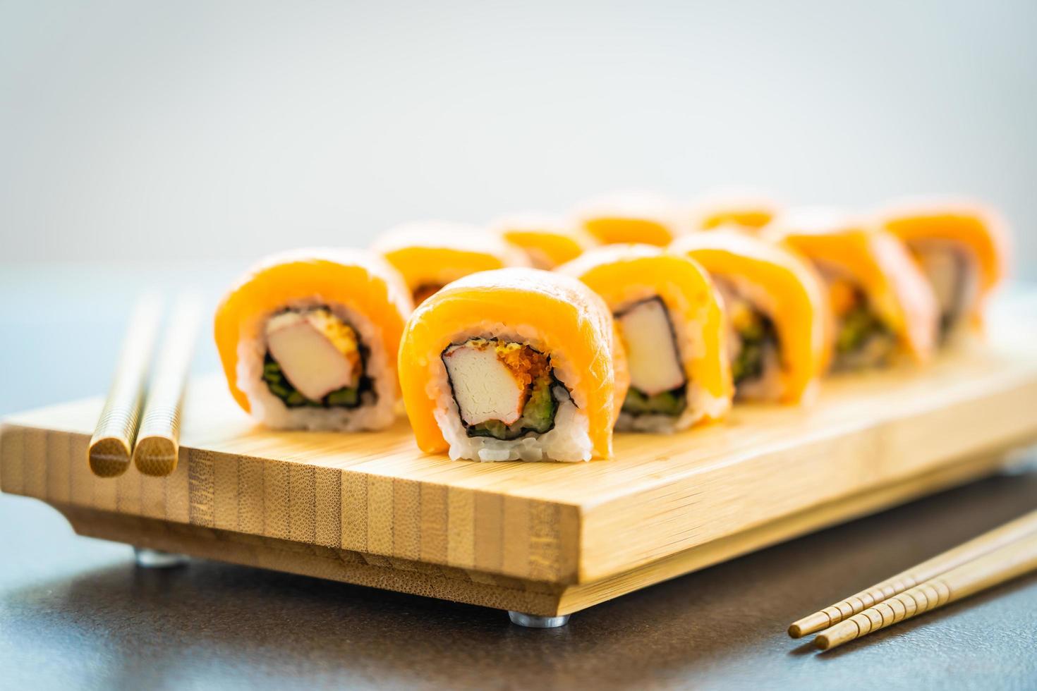 Rouleaux de sushi au saumon sur plaque de bois photo