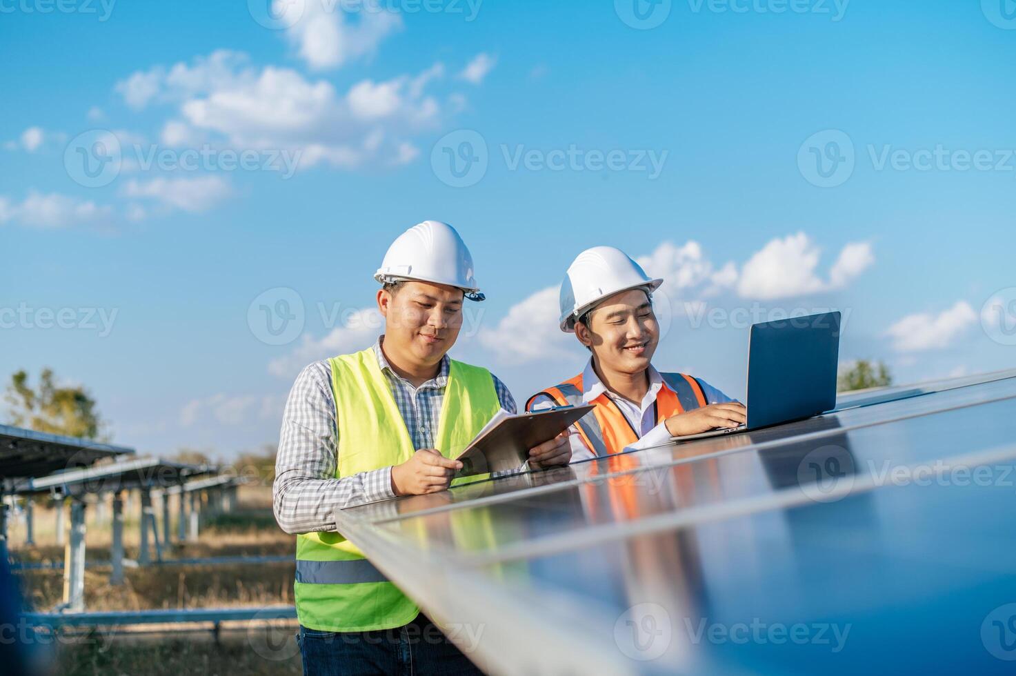 deux ingénieurs discutent pendant qu'ils travaillent dans une ferme solaire photo