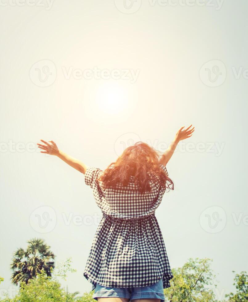 Jeune femme élever sa mains dans le ciel avec lever du soleil donc frais. photo