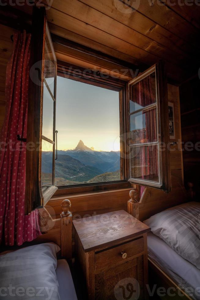une Montagne paysage photographié de une loger, le fenêtre formes le Cadre de le image photo