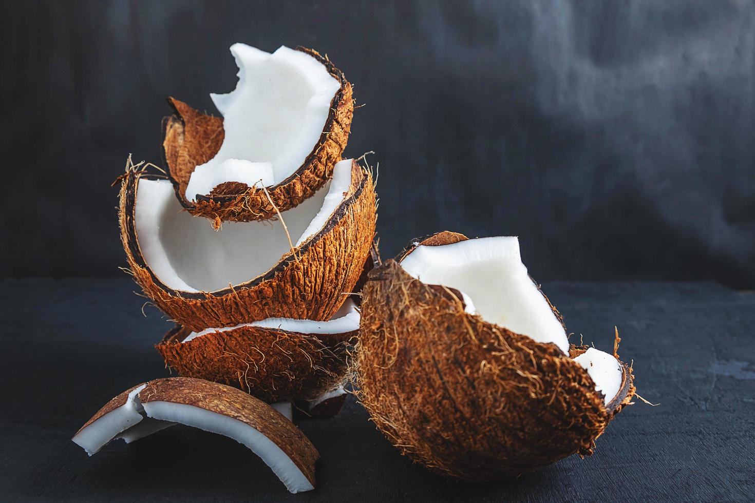 Noix de coco coupée en deux sur un fond de tableau noir photo