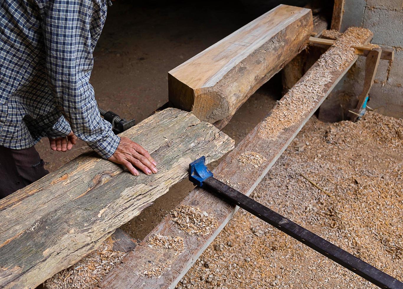 Homme ajustant une planche de bois dans un atelier de menuiserie photo