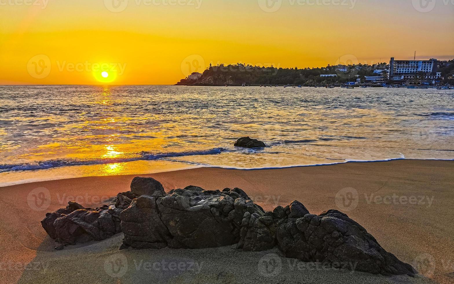 coloré d'or le coucher du soleil gros vague rochers plage puerto escondido Mexique. photo