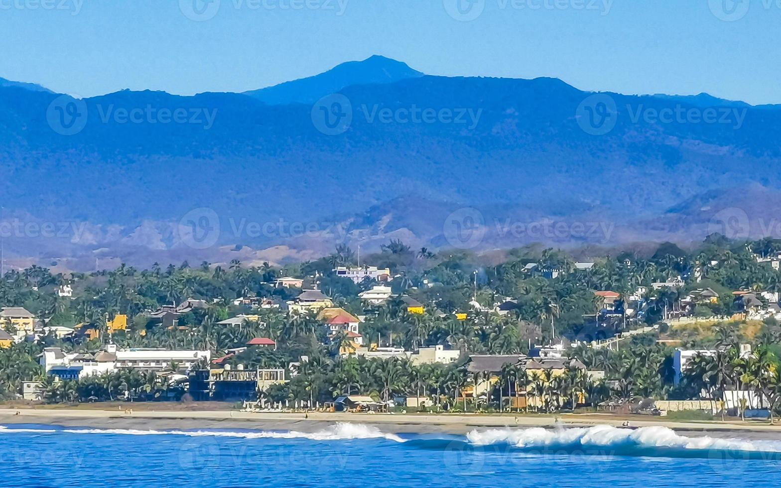 Soleil plage falaises rochers vagues paumes montagnes puerto escondido Mexique. photo