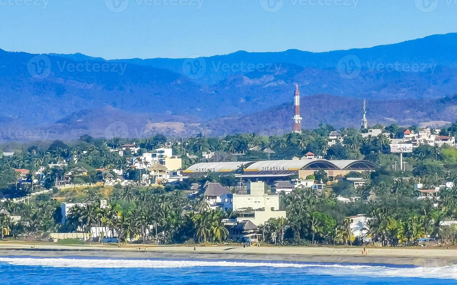 Soleil plage falaises rochers vagues paumes montagnes puerto escondido Mexique. photo