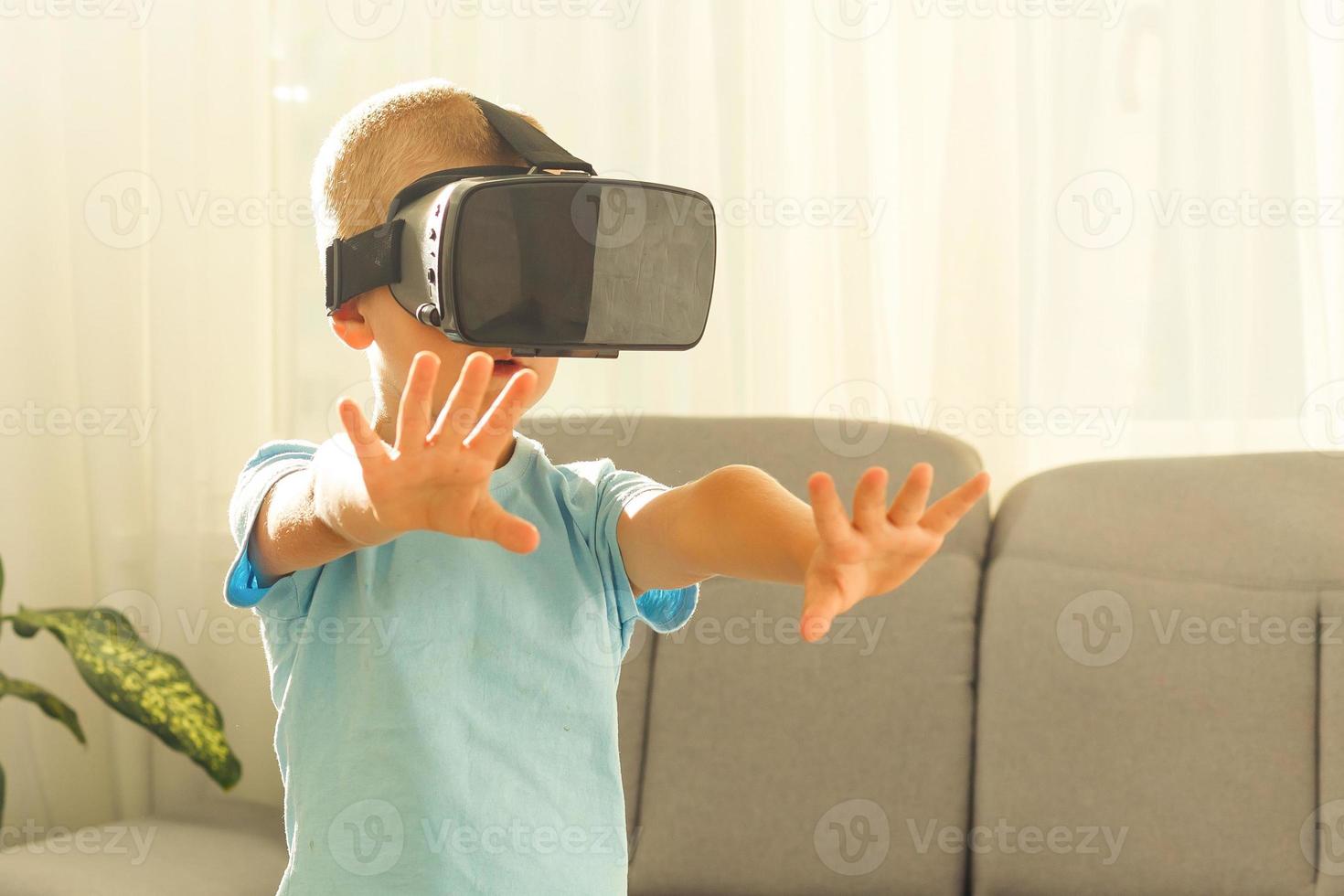 fasciné peu garçon en utilisant vr virtuel réalité des lunettes de protection photo