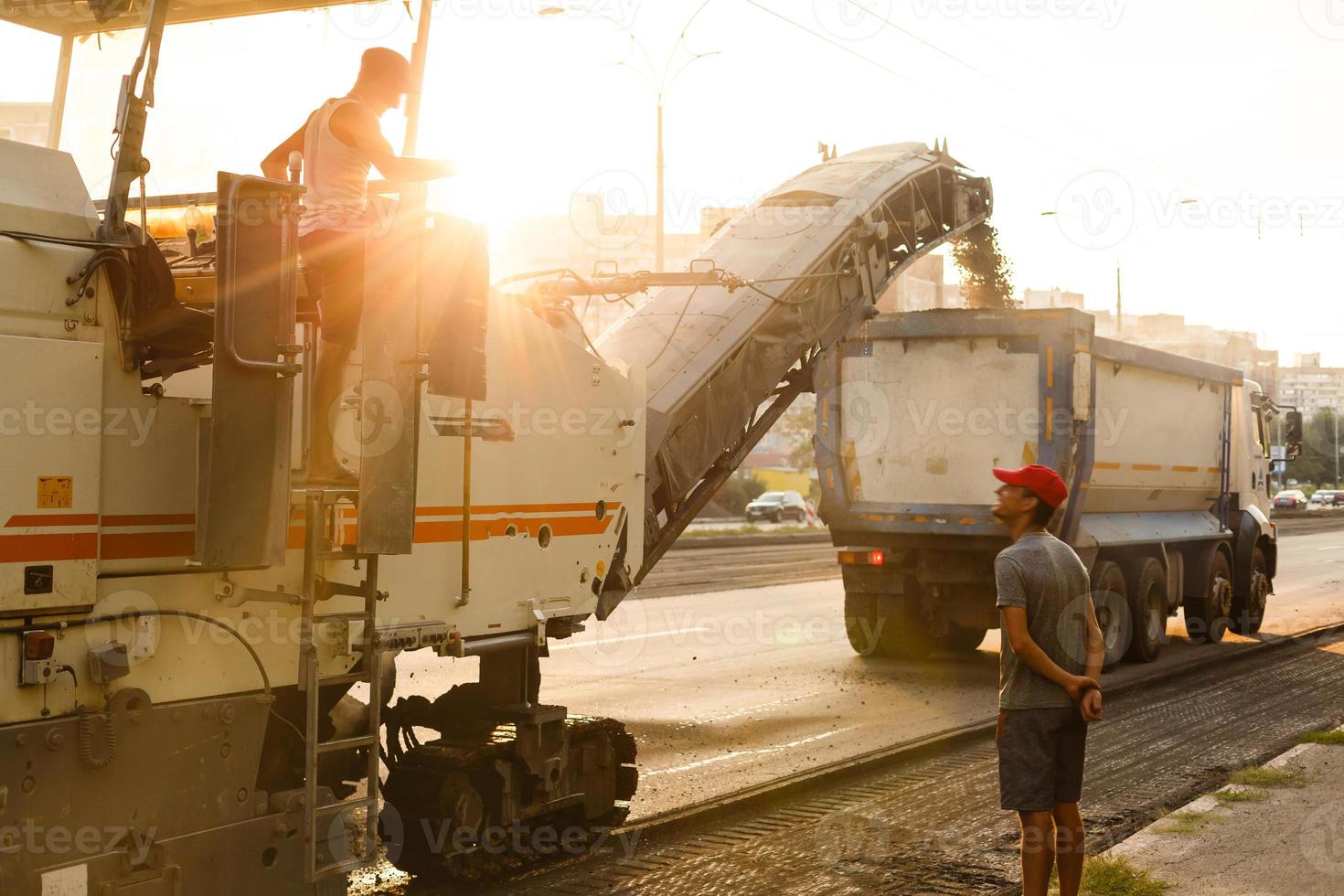 magnifique le coucher du soleil au dessus le route rouleau travail sur le Nouveau route construction site photo