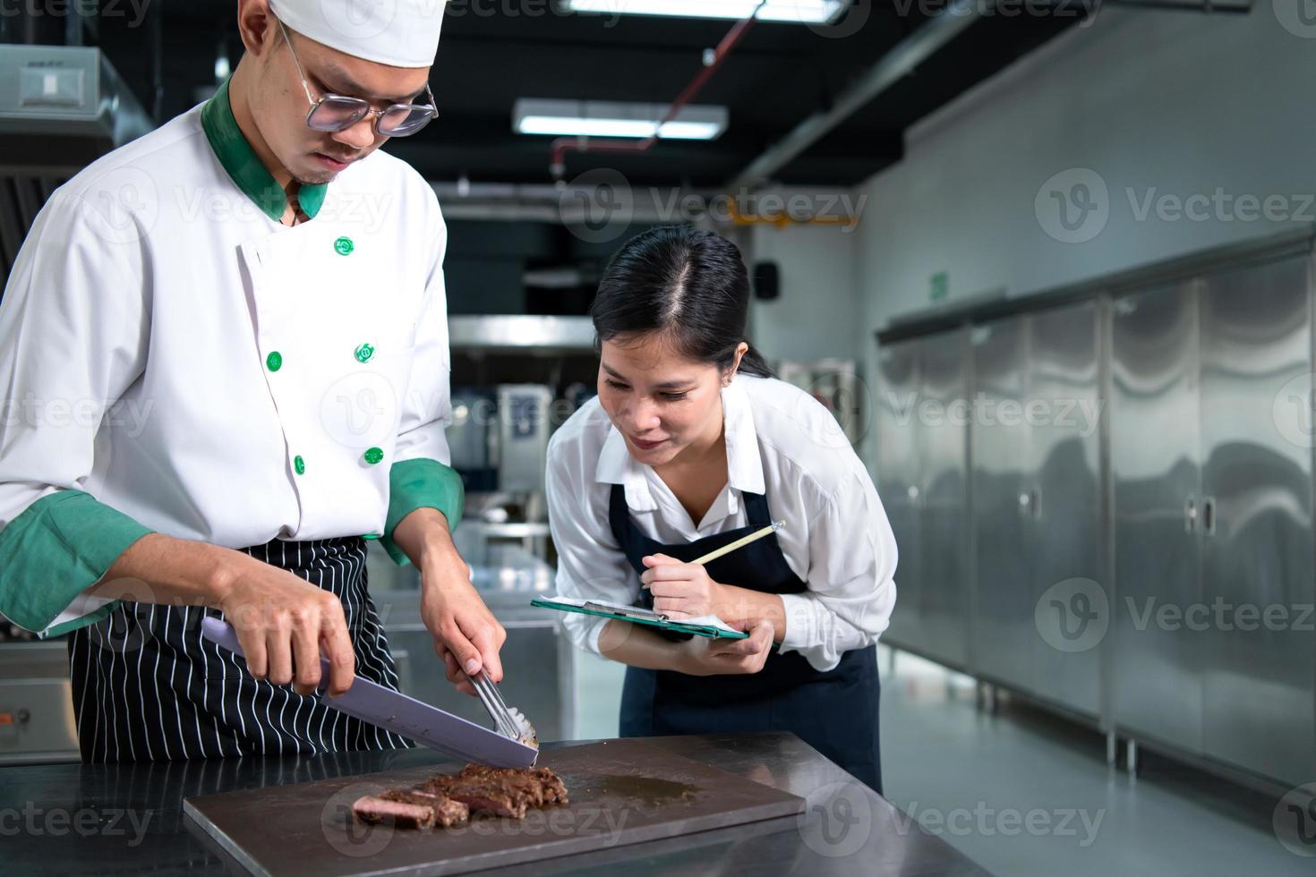 étudiant cuisine apprenti prendre Remarques sur chaque étape comme le chef cuisiniers dans le culinaire de l'académie cuisine. photo