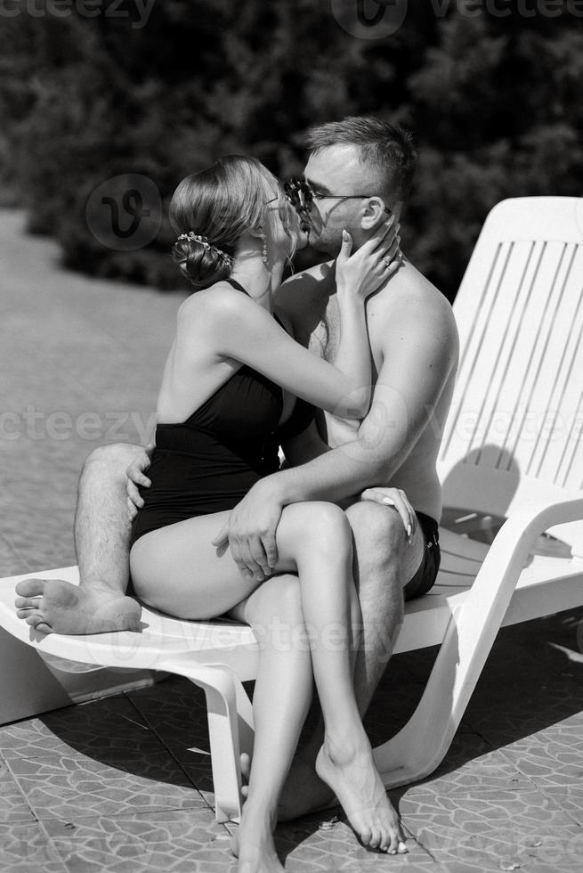 gars et une fille dans baignade costume sont relaxant, près le bleu bassin photo