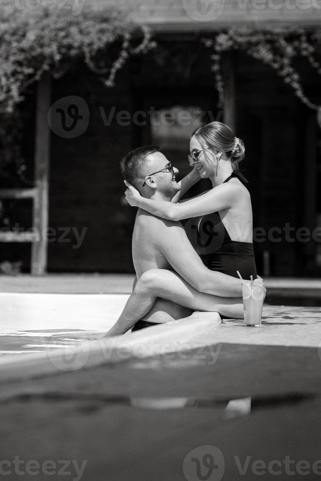 gars et une fille dans baignade costume sont relaxant, près le bleu bassin photo