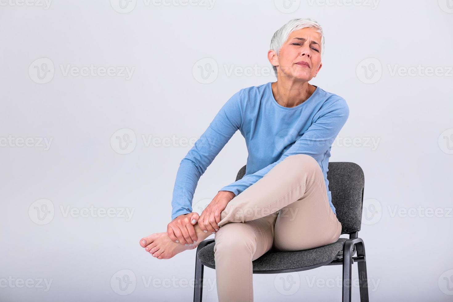 vieux âge, santé problème et gens concept - Sénior femme Souffrance de douleur dans jambe à maison. Sénior femme en portant sa pied avec douleur. photo