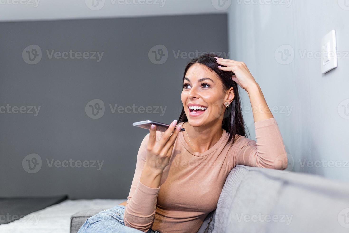 femme en riant tandis que parlant sur haut-parleur. technologie, la communication et gens concept - content femme en utilisant voix commander enregistreur sur téléphone intelligent photo