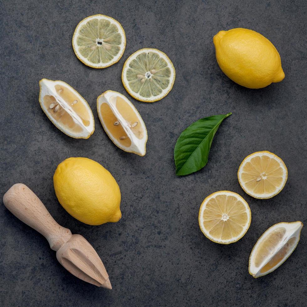 citrons et presse-agrumes sur fond sombre photo