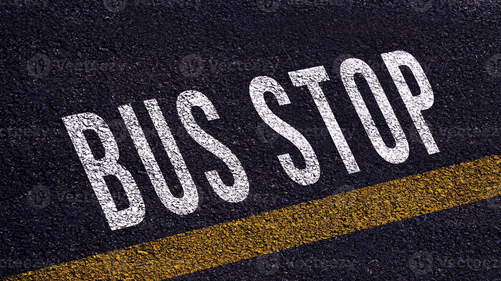 autobus Arrêtez texte écrit et Jaune ligne sur le route dans milieu de le asphalte route, autobus Arrêtez mot sur rue. photo