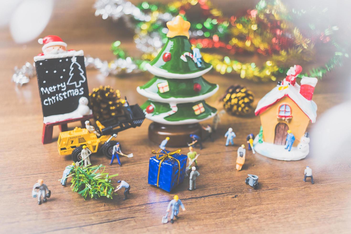Personnes miniatures créant des décorations de Noël sur un fond de bois photo