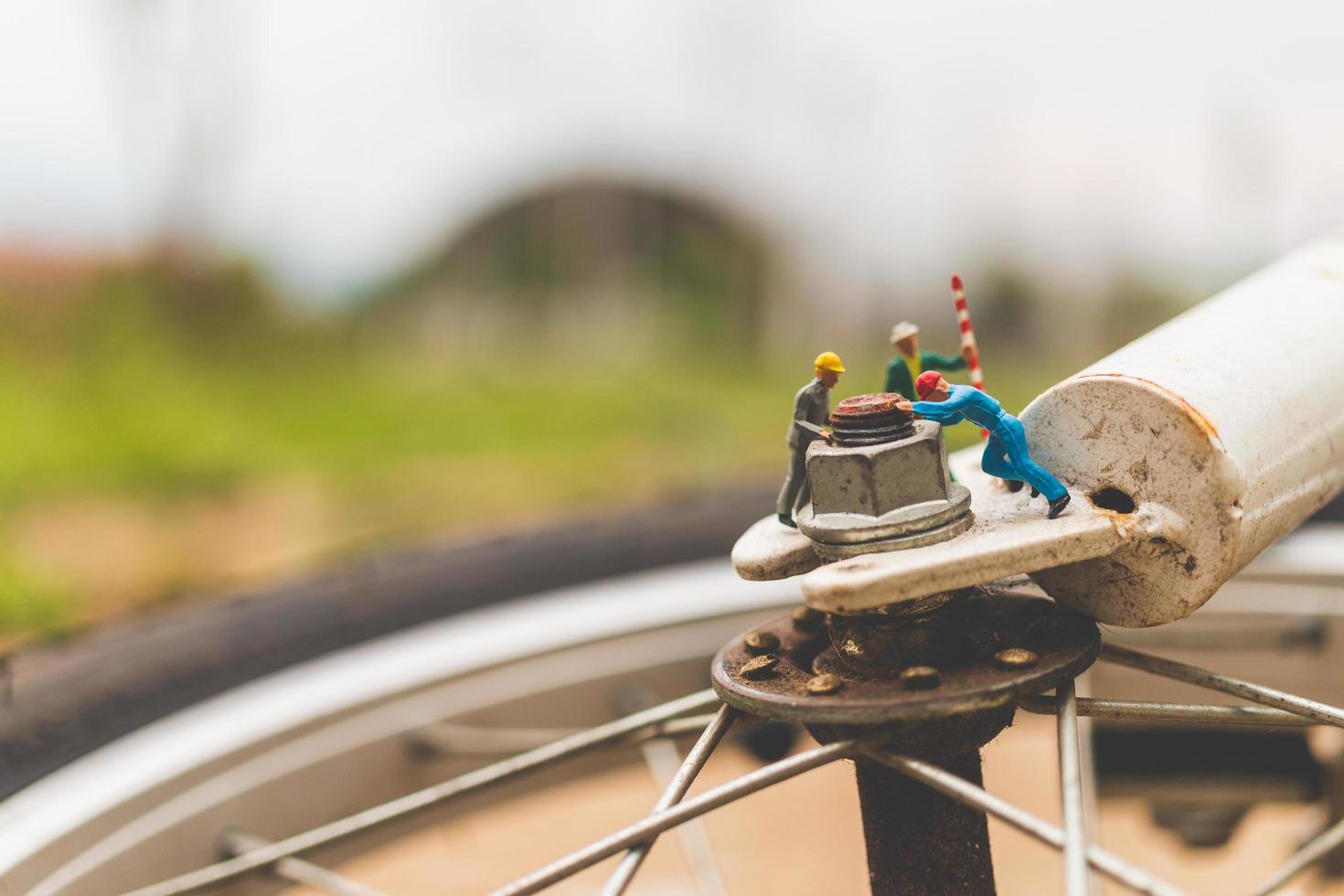 Mécanique miniature réparant un vélo, concept d'atelier photo