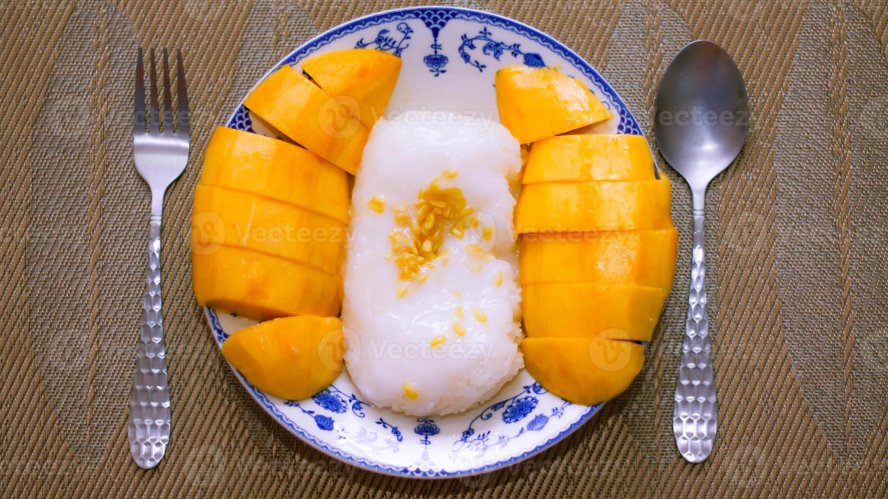 mangue gluant riz surmonté avec noix de coco Lait et soja mis dans une traditionnel chinois style plat sur une en bois tableau. photo