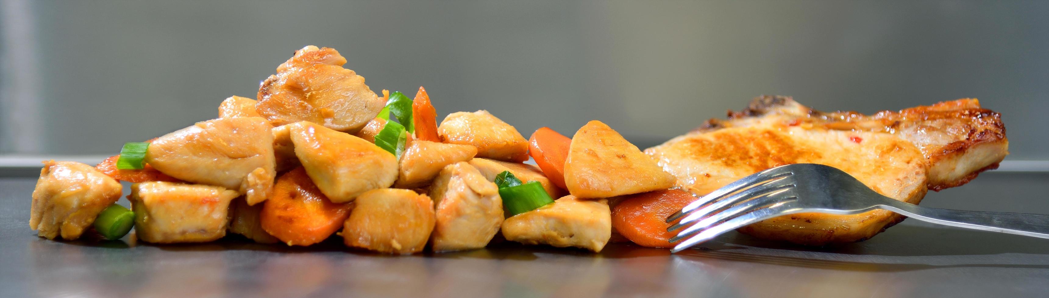 tranches assaisonnées de poulet rôti aux carottes et poireaux sur fond en acier inoxydable photo