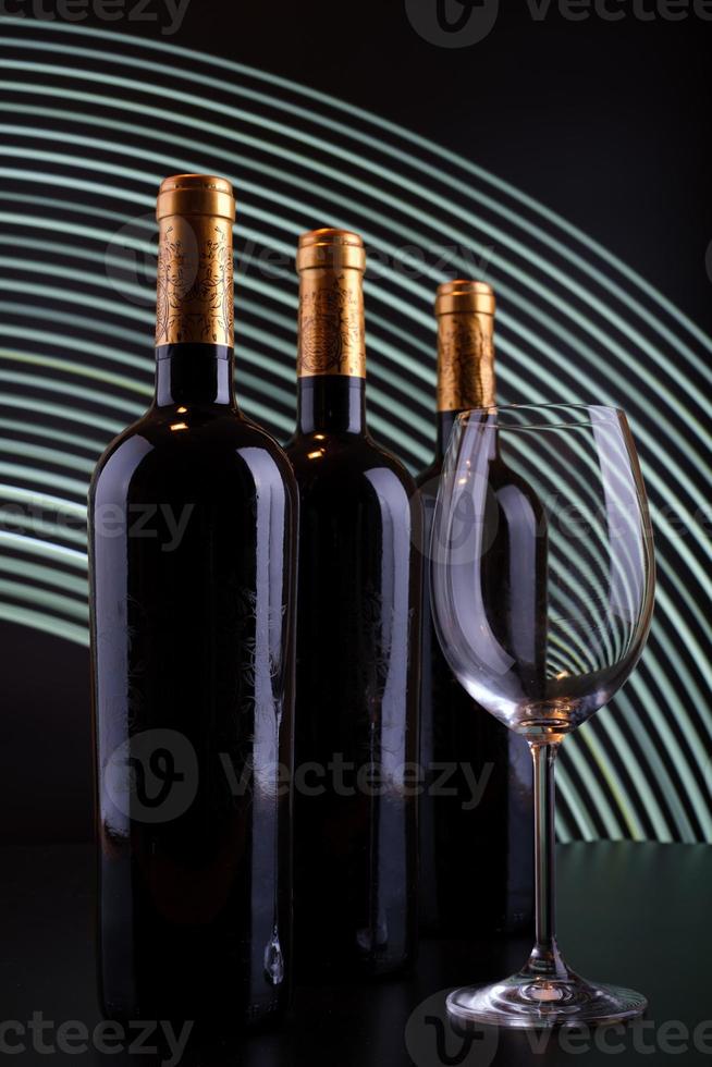 bouteilles de vin et verre avec fond de lignes blanches photo