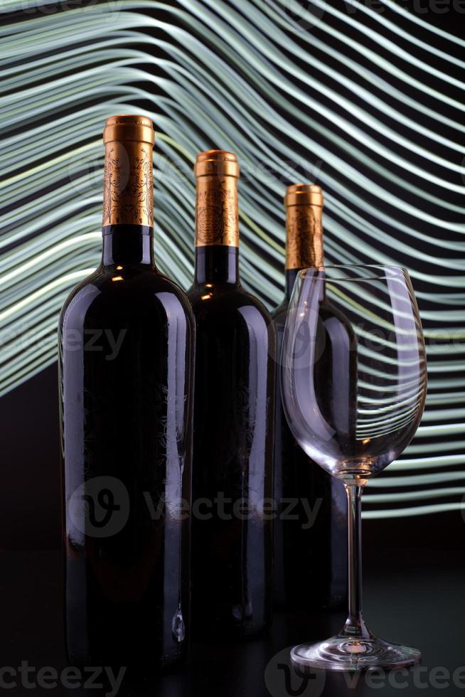 bouteilles de vin et verre avec fond de lignes blanches photo