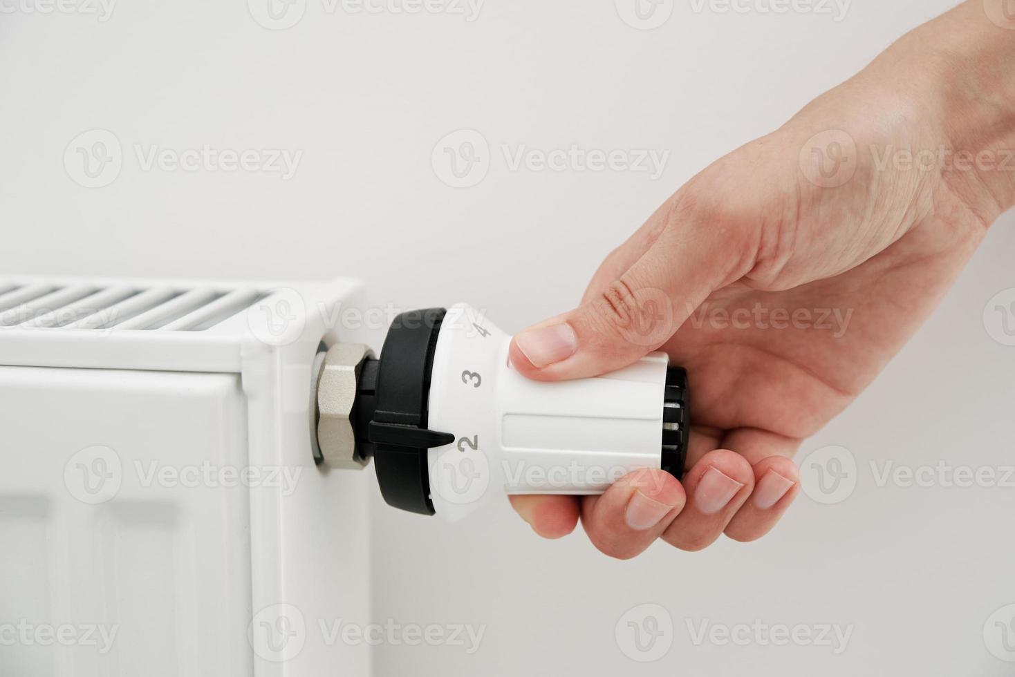 main de femme ajustant la température sur le radiateur de chaleur photo