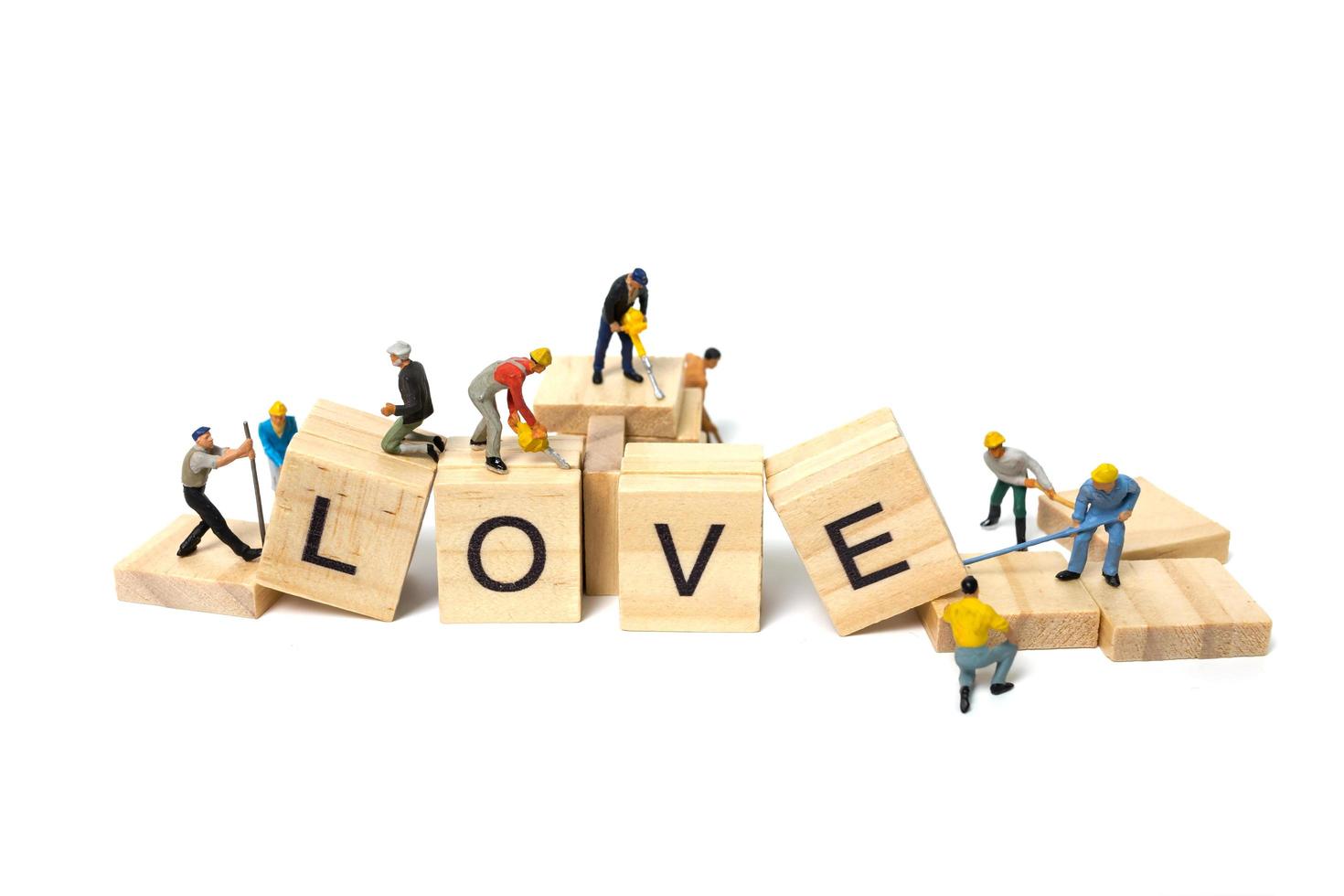 Travailleurs miniatures construisant le mot amour sur des blocs de bois avec un fond blanc, concept de la Saint-Valentin photo