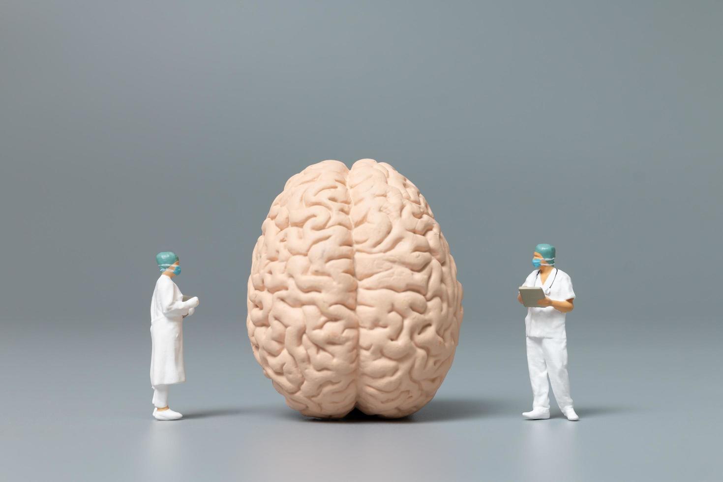 Médecin miniature et infirmière observant et discutant du cerveau humain, de la science et du concept médical photo