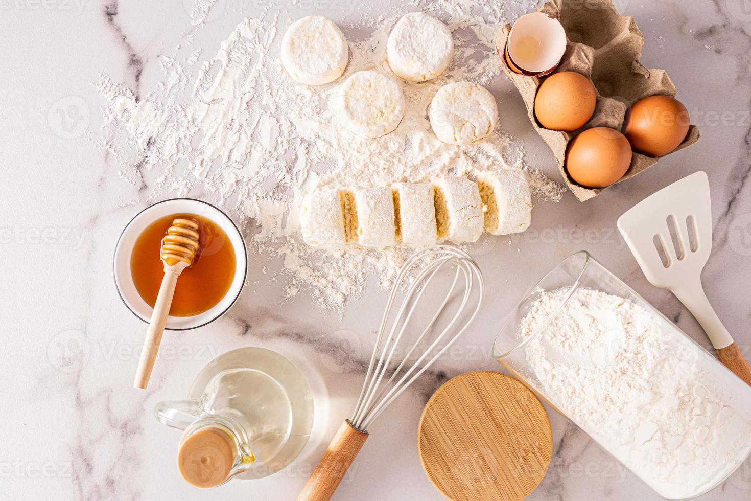 Haut vue de fraîchement cuit gâteaux au fromage et Ingrédients pour cuisson. œufs, Miel, beurre dans une bouteille. délicieux petit déjeuner. photo