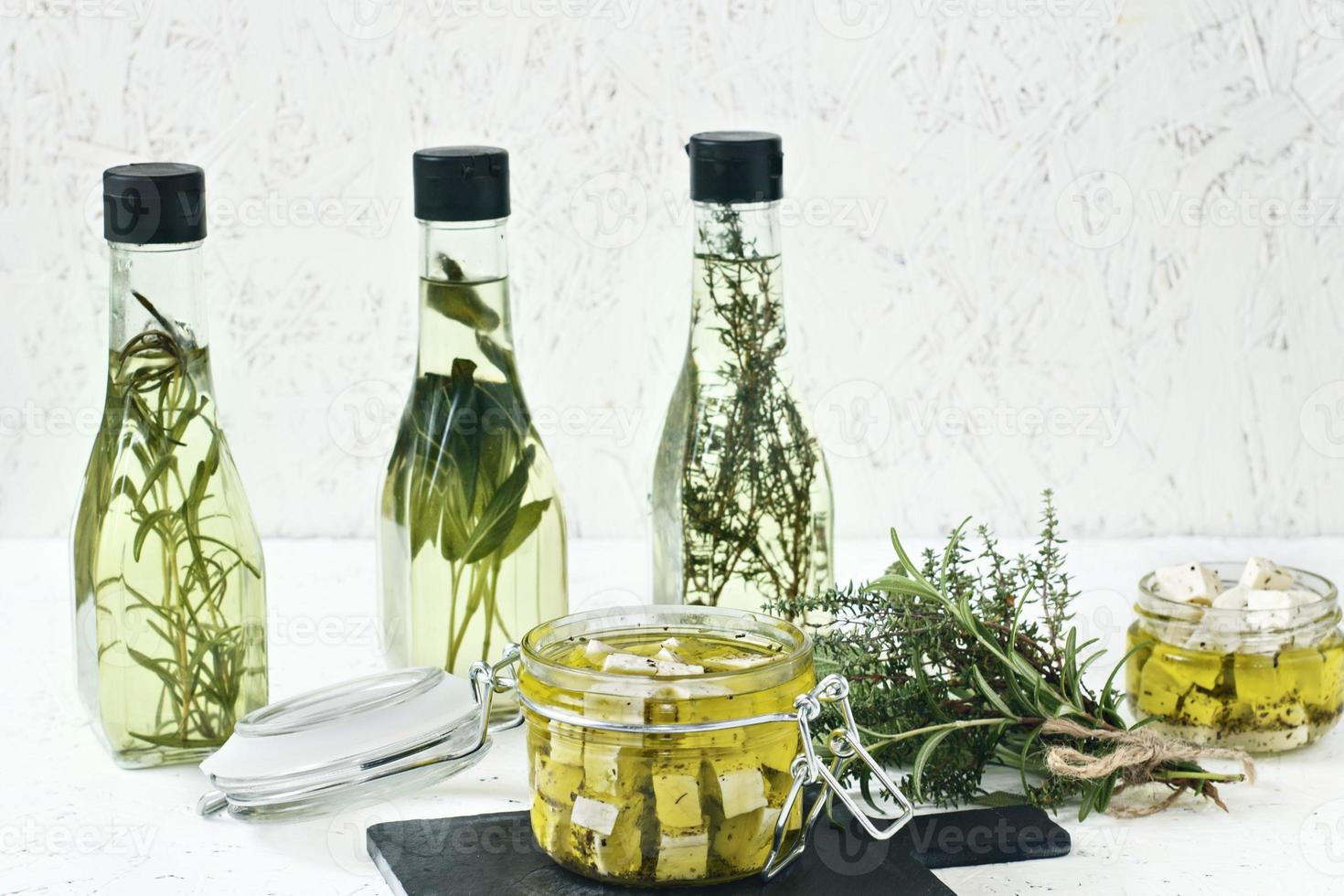 Feta marinée dans un bocal en verre, épices et huile d'olive aromatisée sur un fond en bois photo