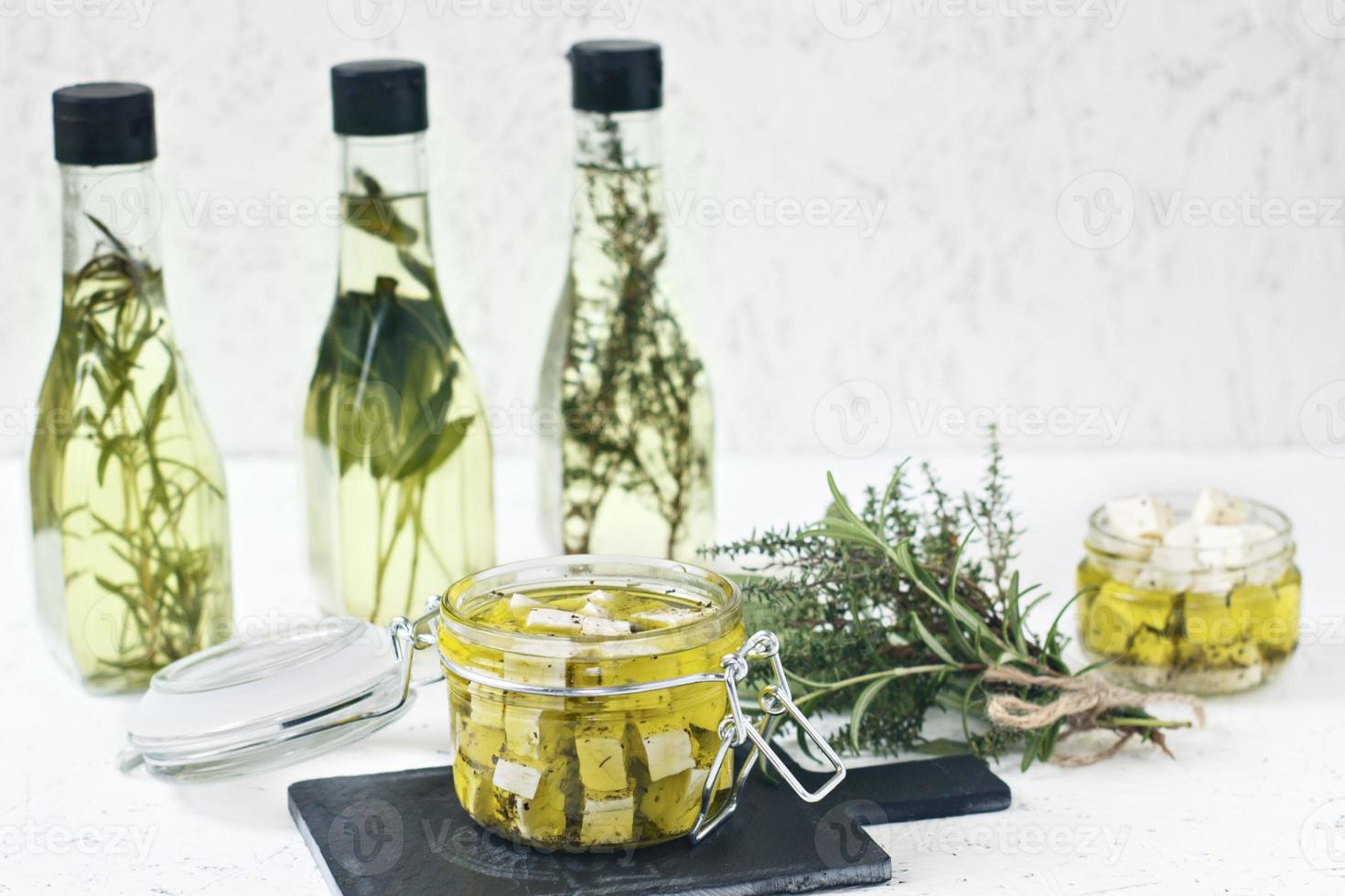Feta marinée dans un bocal en verre, épices et huile d'olive aromatisée sur un fond en bois photo