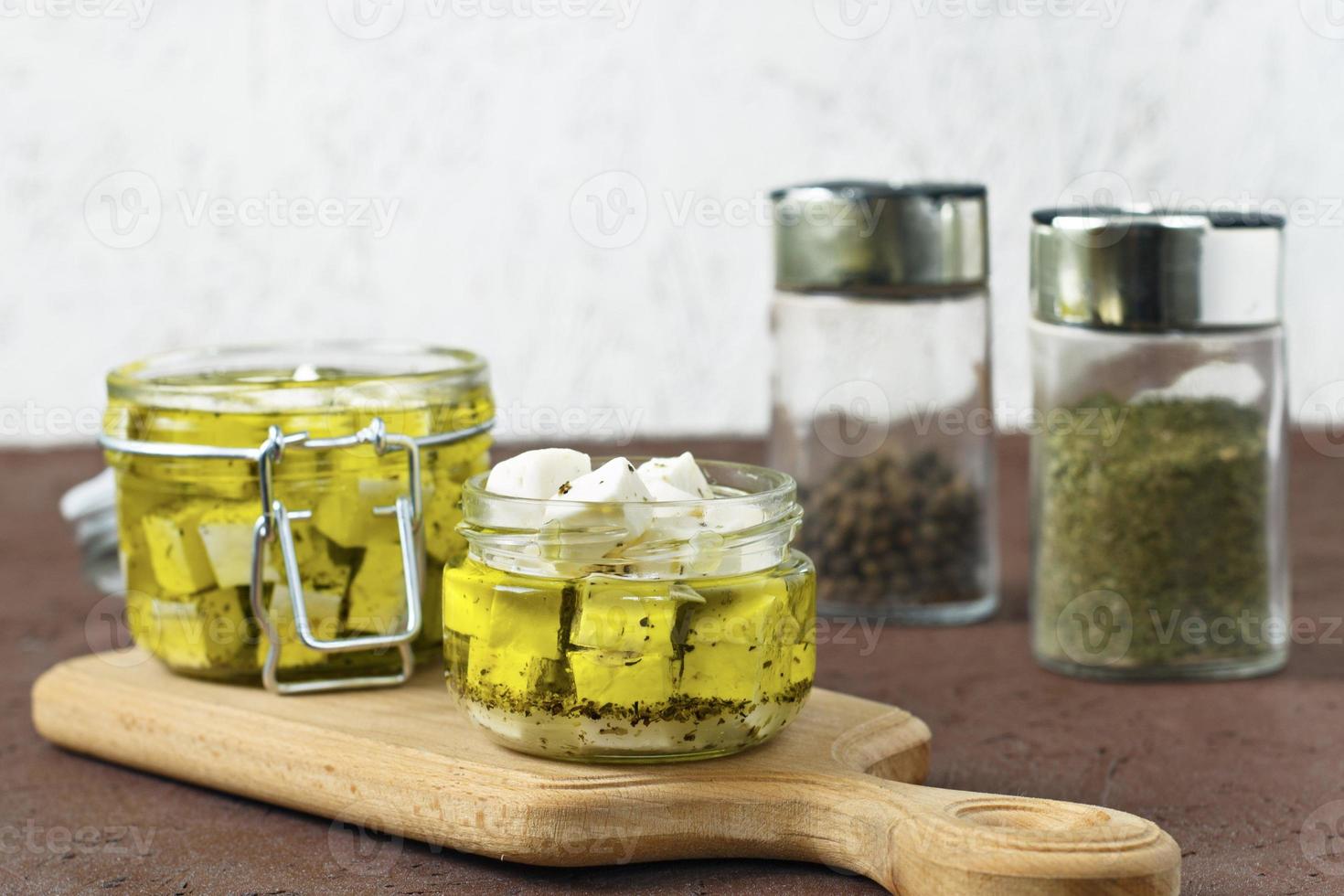 Feta marinée dans un bocal en verre et épices sur un fond blanc photo