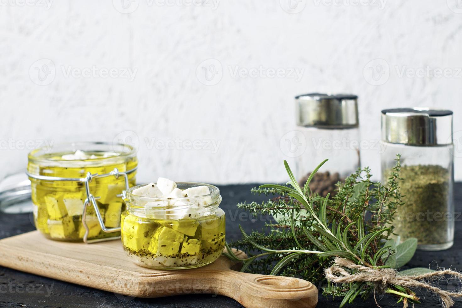 Feta marinée dans un bocal en verre et épices sur un fond blanc photo