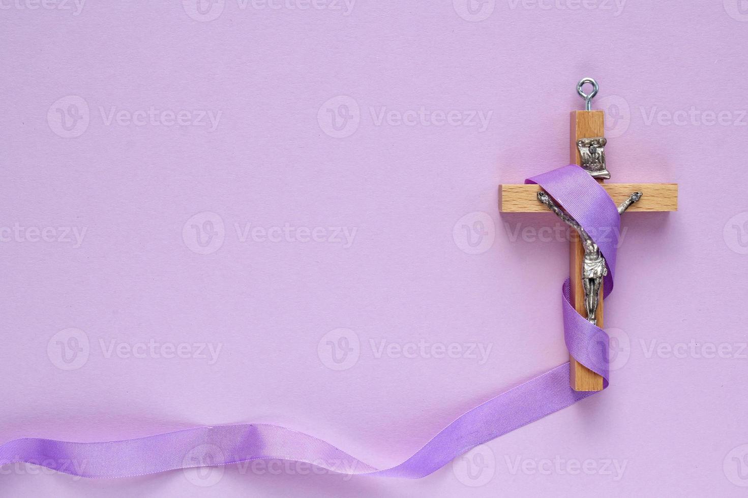 Christian religieux en bois traverser crucifix avec violet ruban sur violet Contexte. catholique religion symbole. bien vendredi, prêté saison, paume dimanche, cendre Mercredi et saint la semaine concept photo