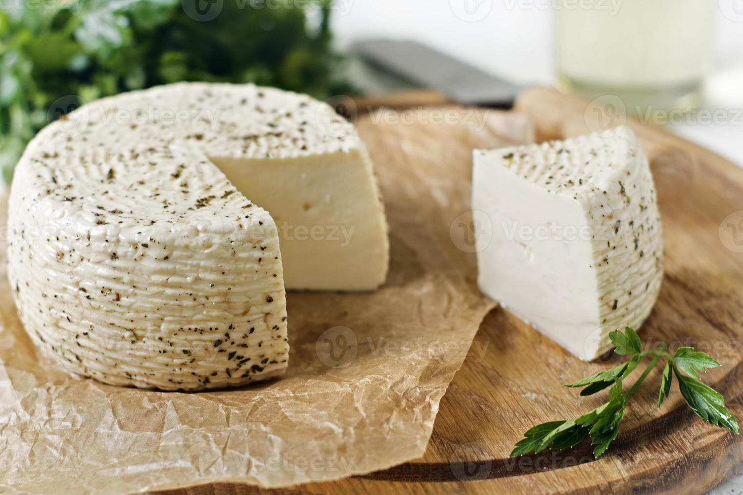 Fromage blanc sur une planche de bois sur fond blanc photo